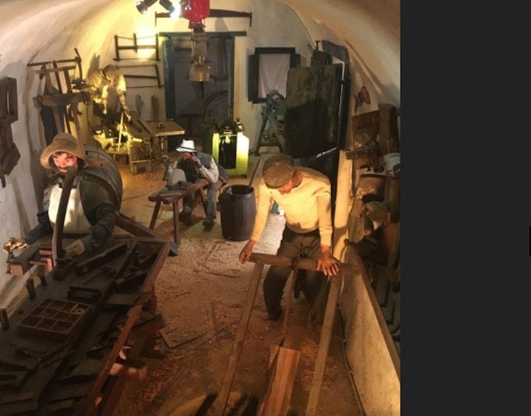 exhibit shows man manual ploughing at 'Koutsoyannopoulos Wine Museum'